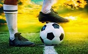 feet of football player tread on soccer ball