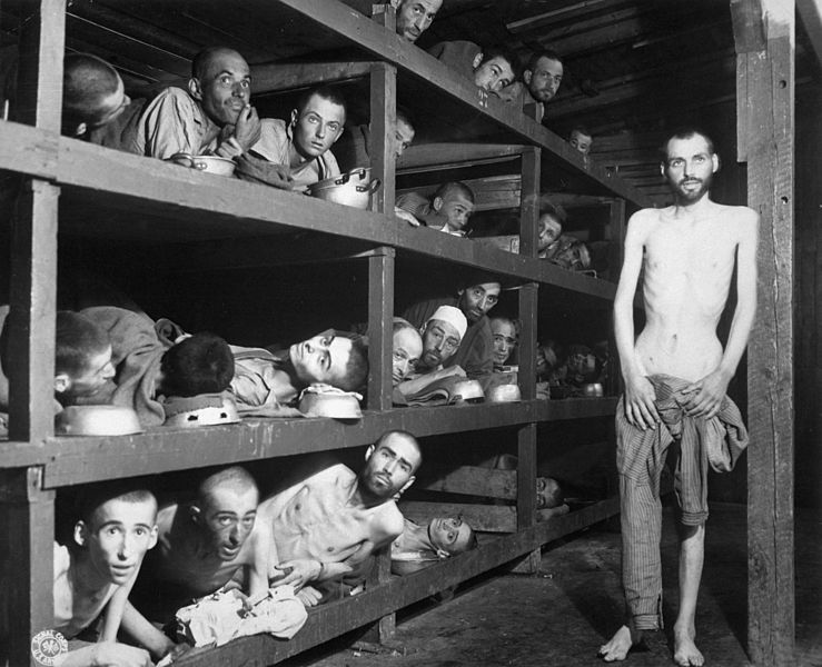 Фотография из концентрационного лагеря Бухенвальд. На ней мы можем видеть Эли Визеля. Он лежит на втором ярусе нар, седьмой слева. Здесь ему не больше 17 лет, но он выглядит стариком. Фото: Википедия. (кликните на снимок, чтобы его увеличить)